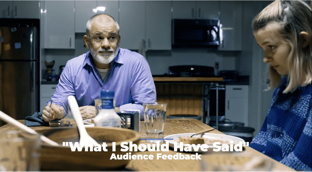 Still from short film depicting a man with a beard looking at a girl who is avoiding his gaze. Both are sitting at a dinner table.